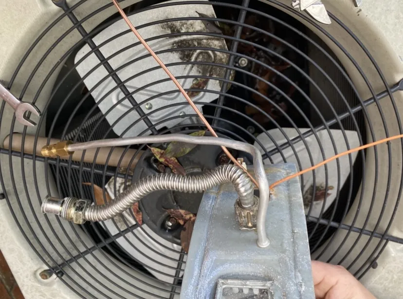 Top-down view into an outdoor condenser unit with the fan grille removed