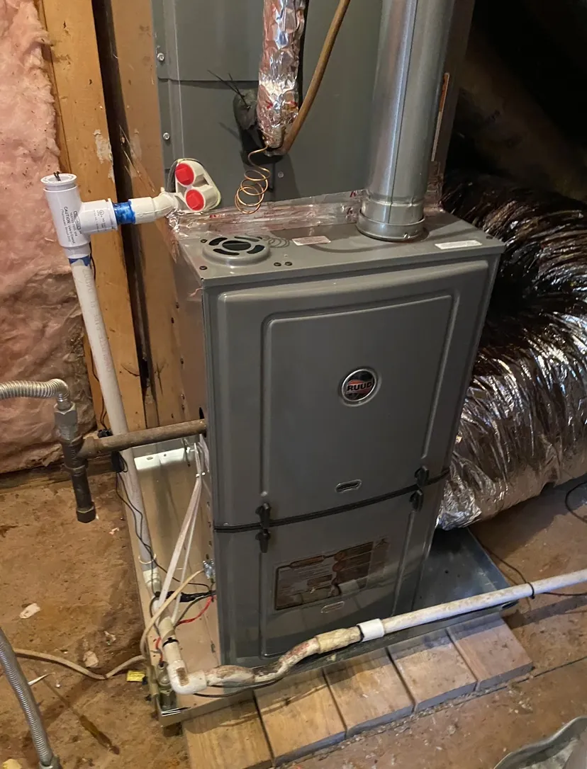 A utility closet with a gas furnace, flex duct and a water heater